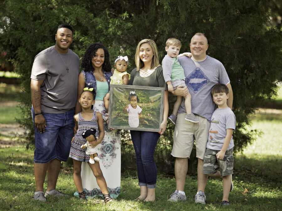 families stand with photo of organ donor