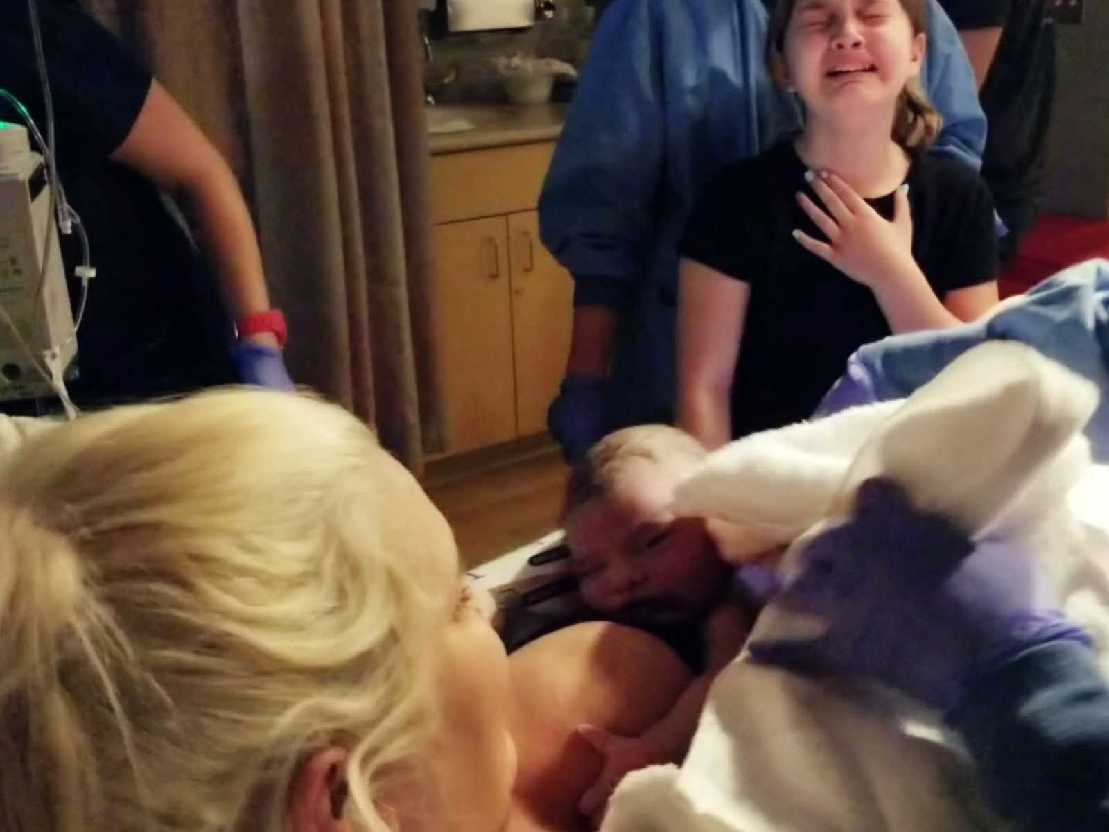 Menina ajuda mãe no parto