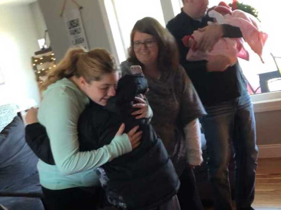 Son hugs woman who carried adoptive sister 