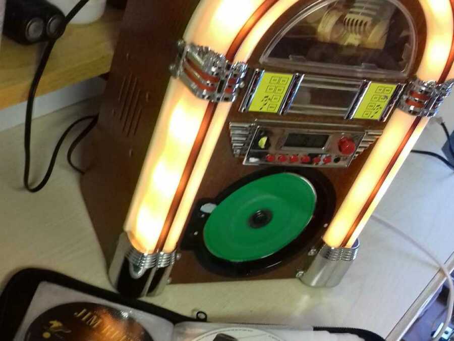 Colorful jukebox sitting on table with cds next to it