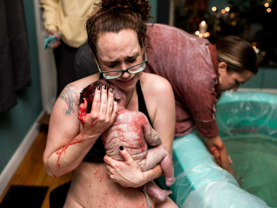 Crying postpartum mom holding 11-pound newborn
