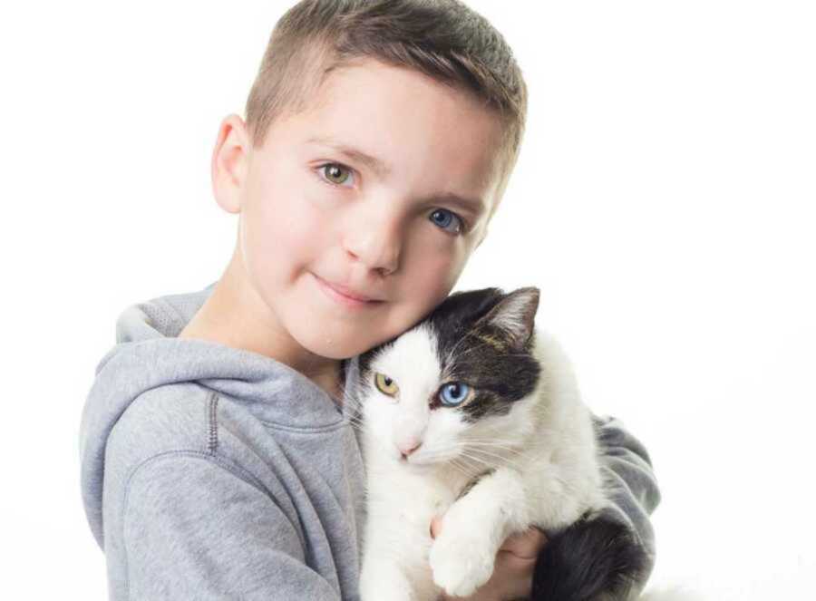 Boy and cat with matching cleft lip and heterochromia iridum