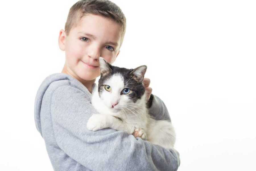 Boy and cat with matching heterochromia iridum
