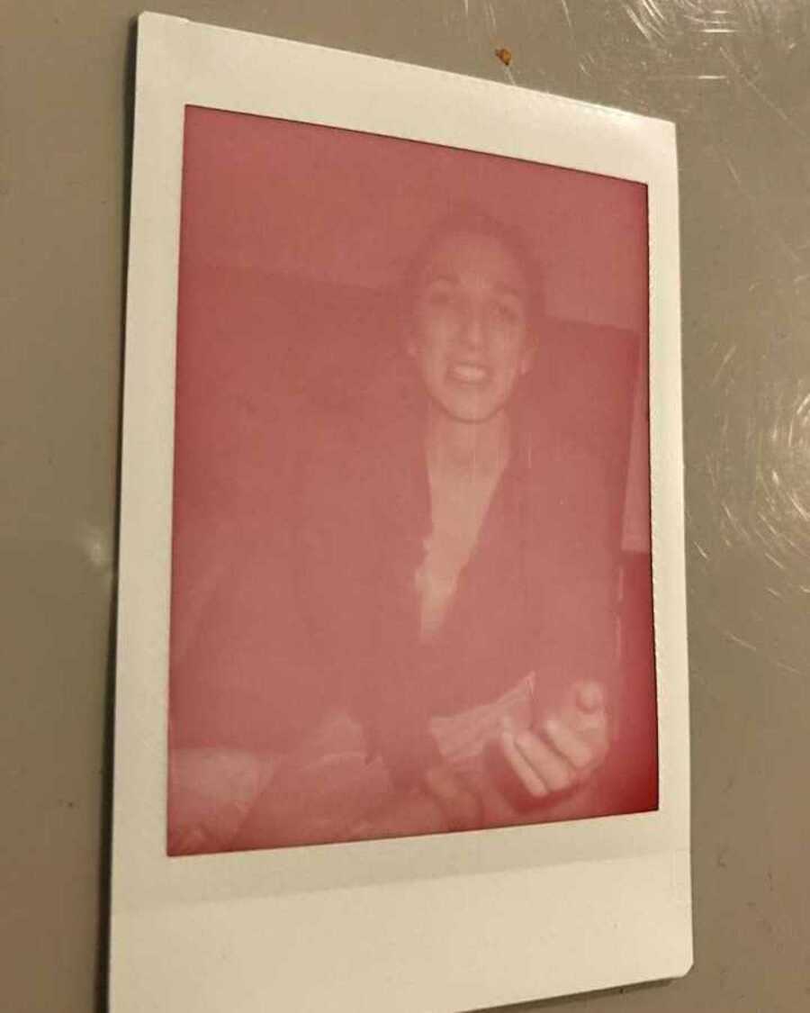Polaroid not fully developed with woman sitting on bed