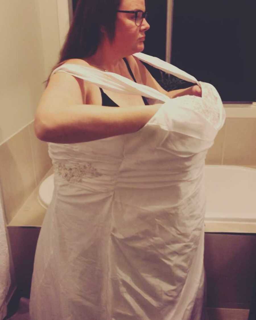 woman stands in wedding dress after major weight loss
