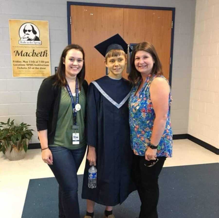 boy with cystic fibrosis on his graduation day with two teachers