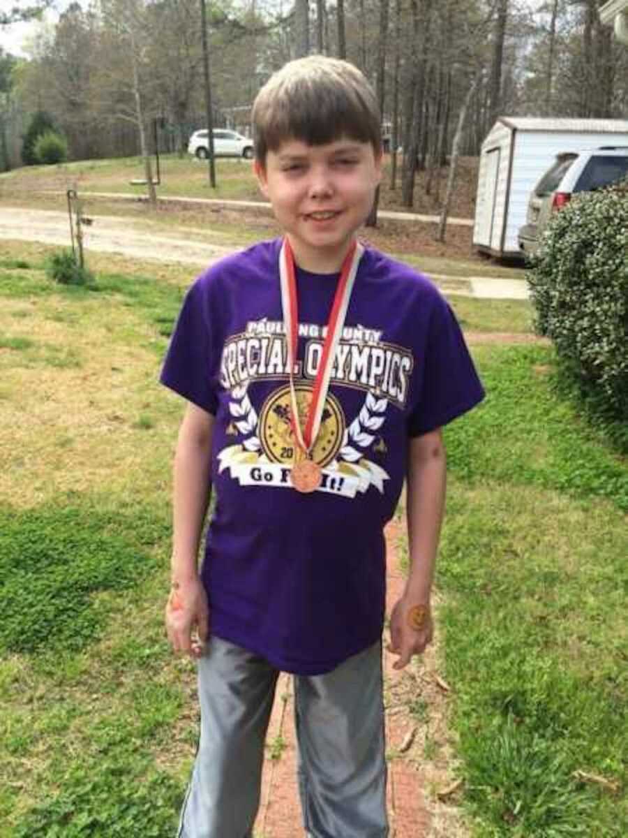 boy with cystic fibrosis wearing a medal