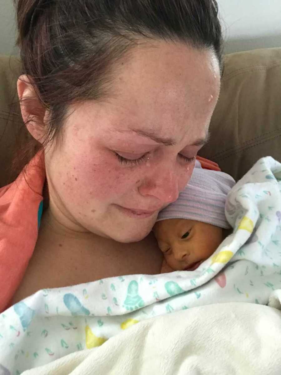 Emotional new mother embraces her dying son