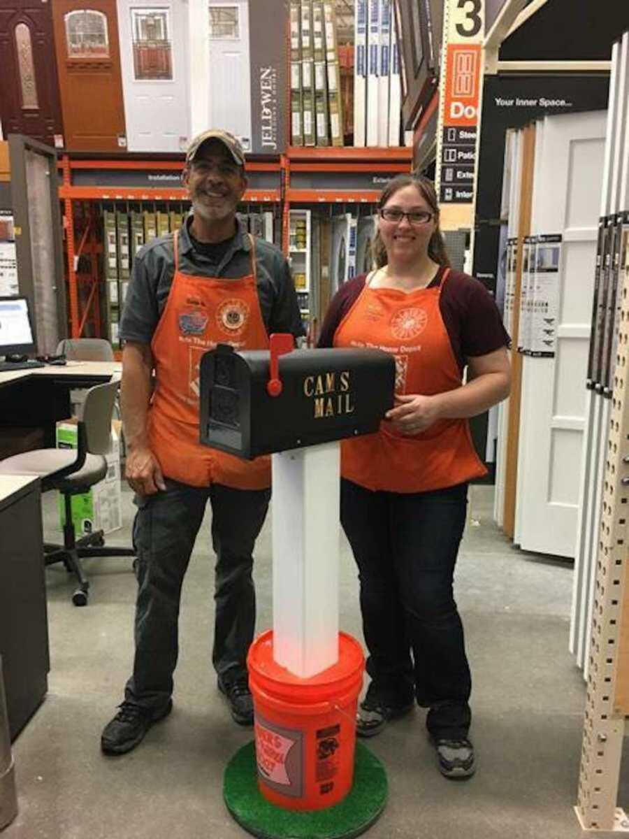 two home depot employees stand with mailbox they made for boy with autism