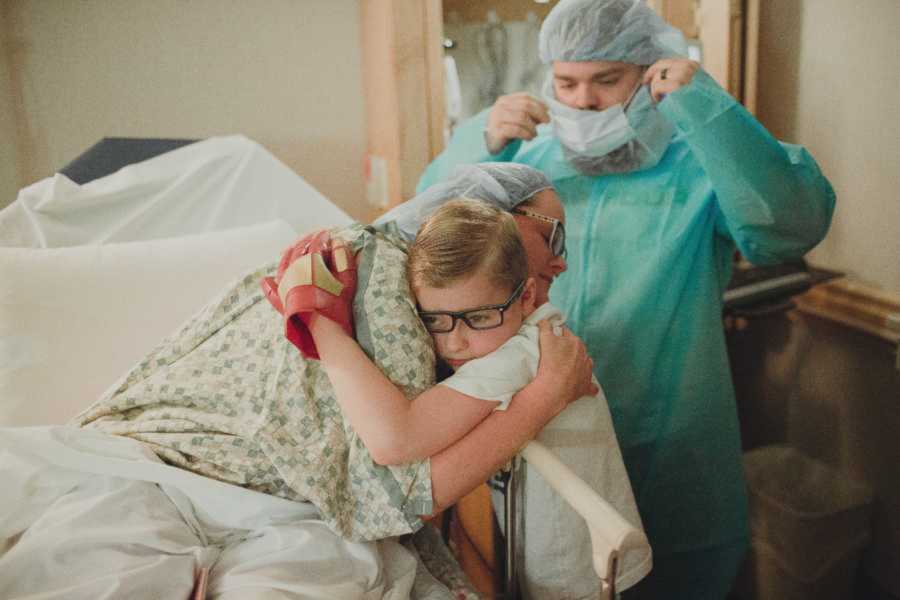 Mom preparing for c-section embraces her son with husband behind her