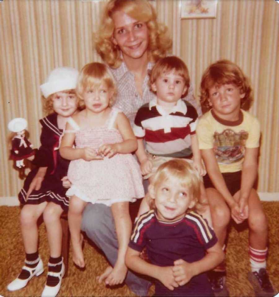 mom sitting on chair with five kids