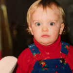 Blonde boy with wide eyes wearing overalls