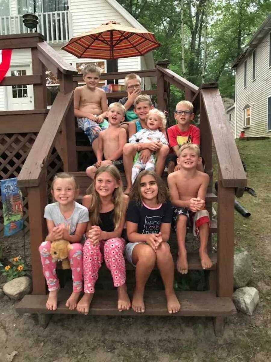 group of children of mothers who met online sitting together on steps