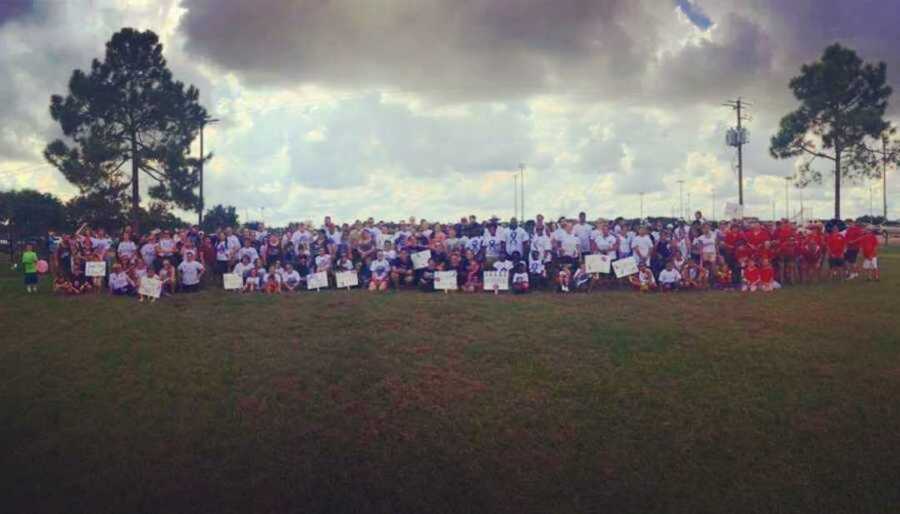 Fight Like A Warrior organization holding up signs on grassy field