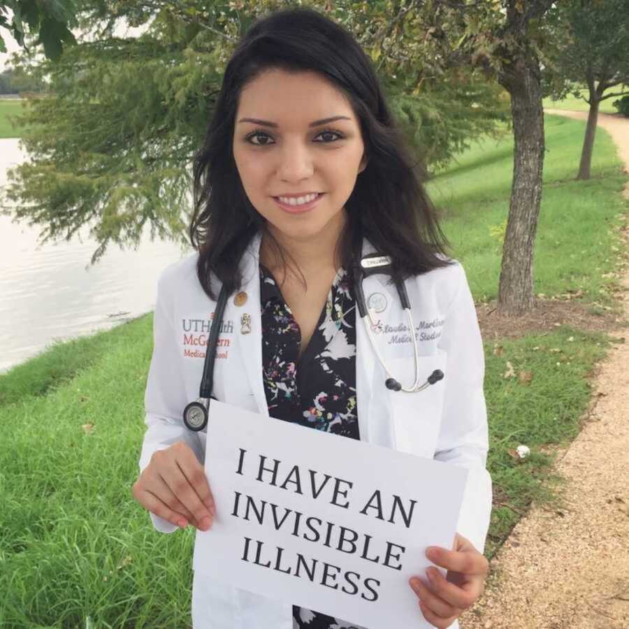 Joyous med student outside in white coat with invisible illness sign
