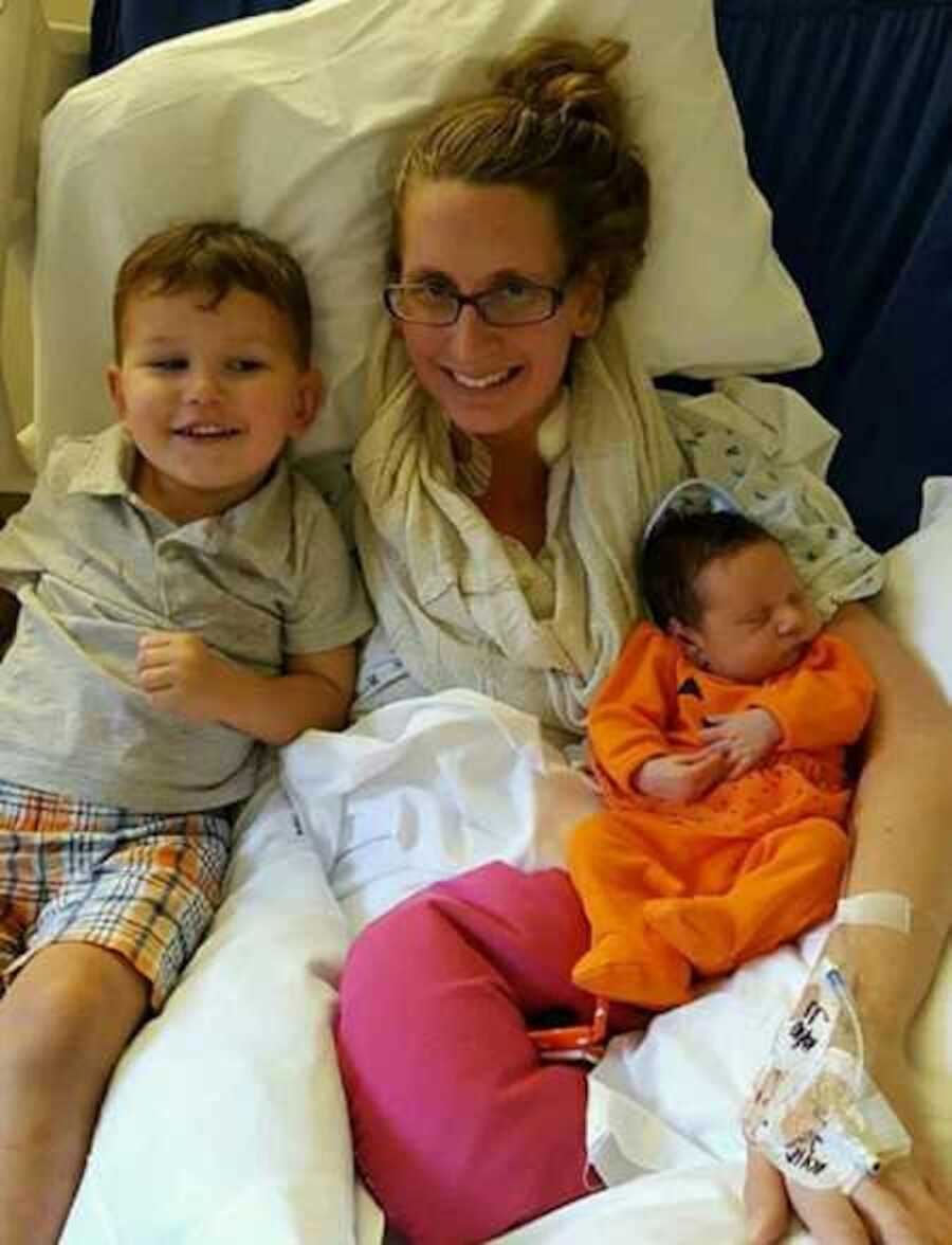 Proud mom in hospital bed with newborn daughter and joyous son