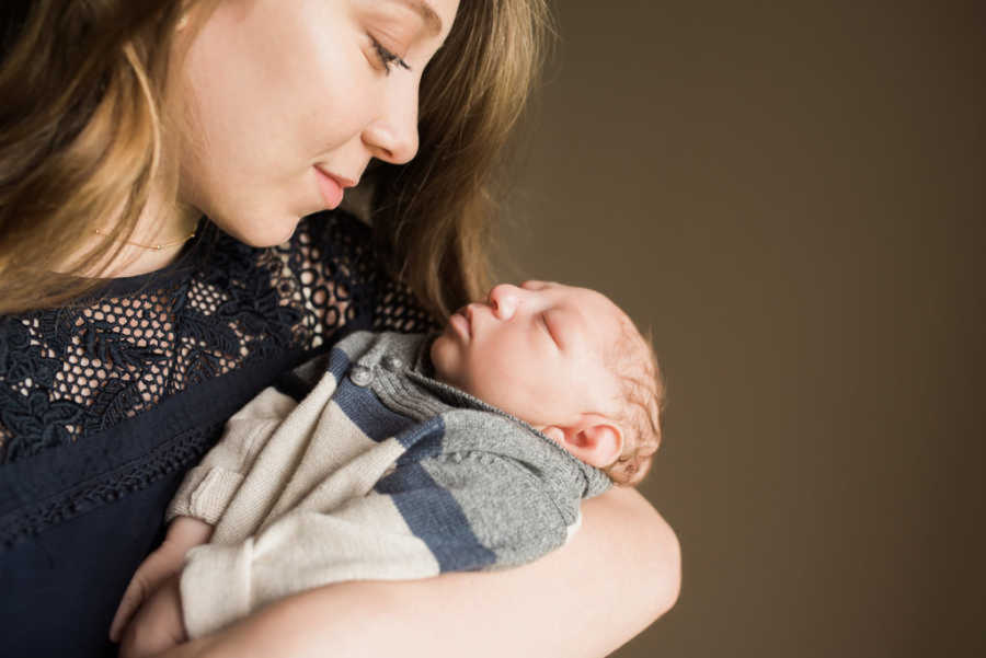 Mom smiling at newborn son with microcephaly