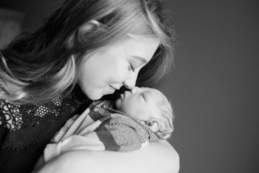 Mom snuggling newborn son