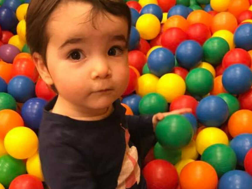 toddler boy sitting in ball pit