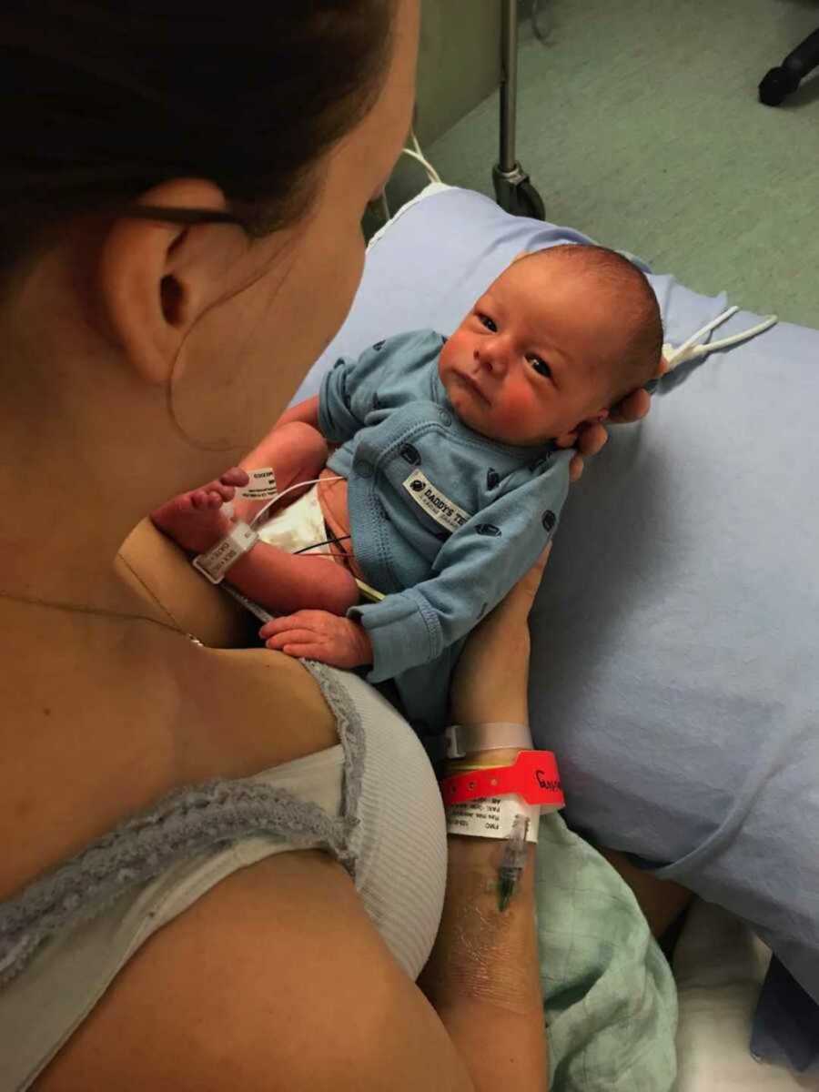 Aerial view of Jehovah's witness woman holding newborn in NICU