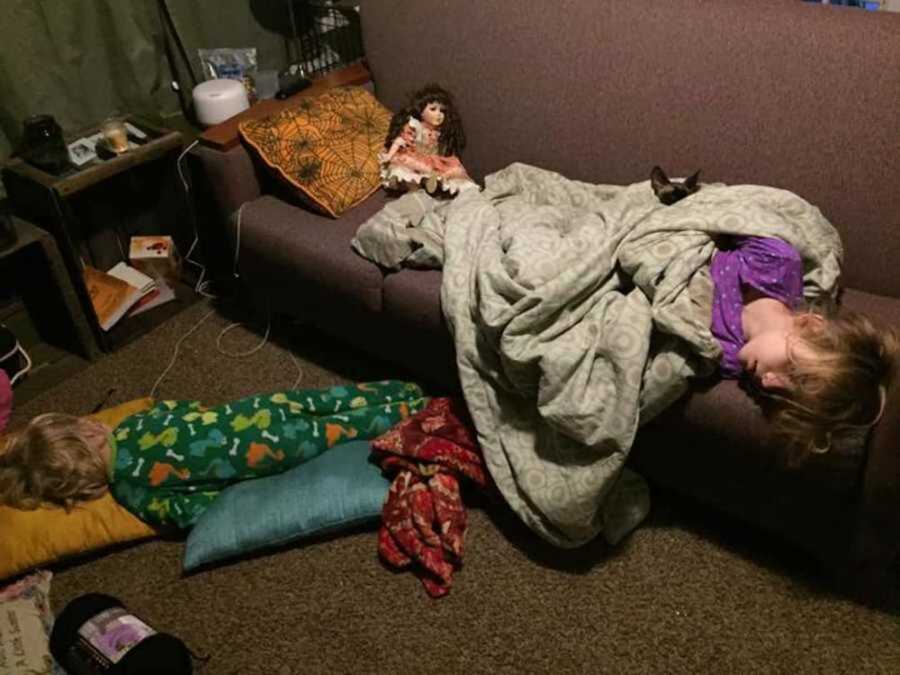 kids sleeping on couch with creepy doll by them
