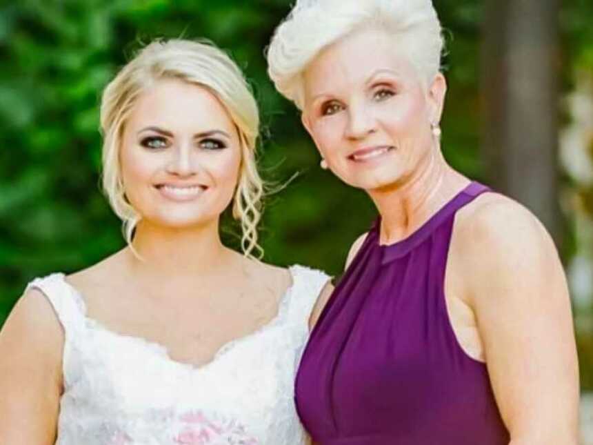 mother and daughter stand together in formal attire on daughter's wedding day