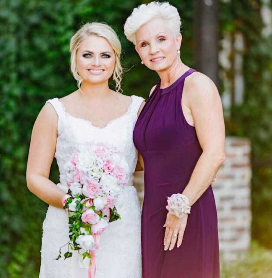 mother and daughter stand together in formal attire on daughter's wedding day