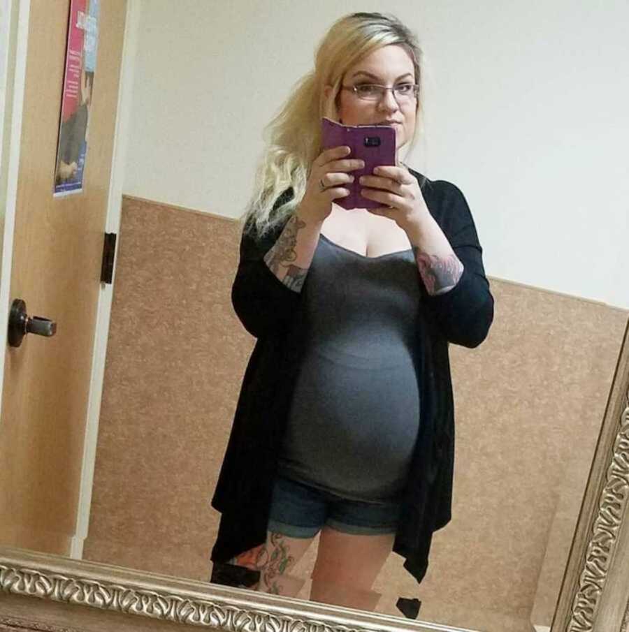 pregnant woman takes selfie in mirror
