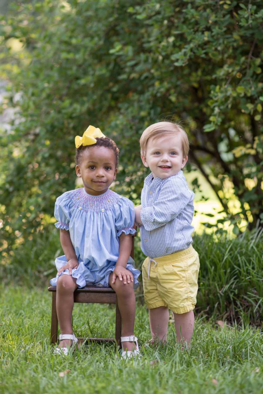 Siblings toddlers posing in grass