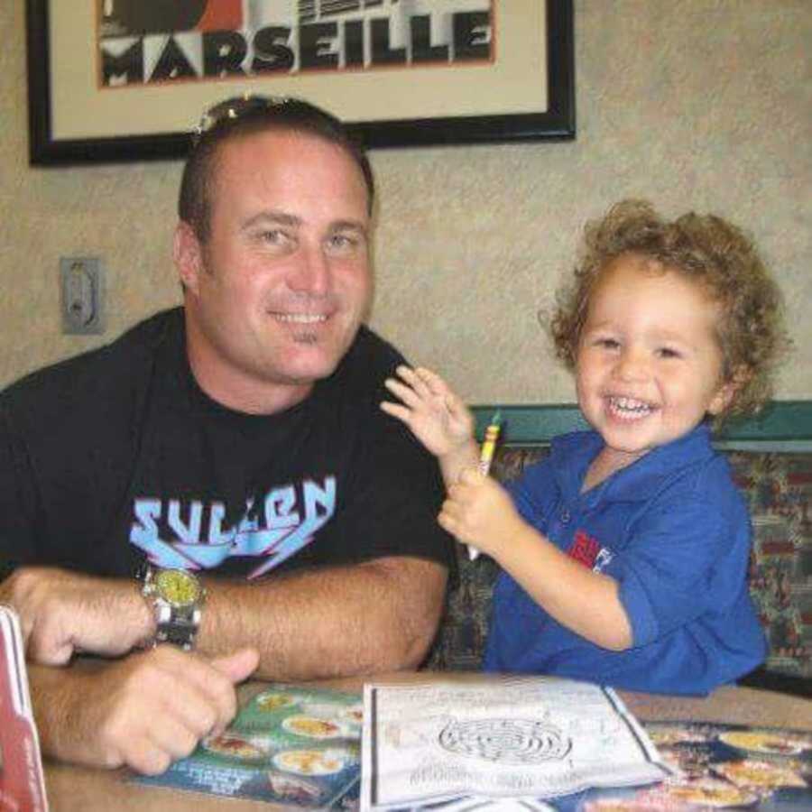 Son and dad smiling in restaurant