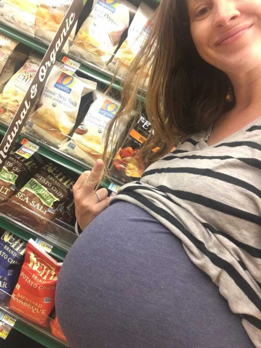 pregnant woman putting up middle finger in grocery store