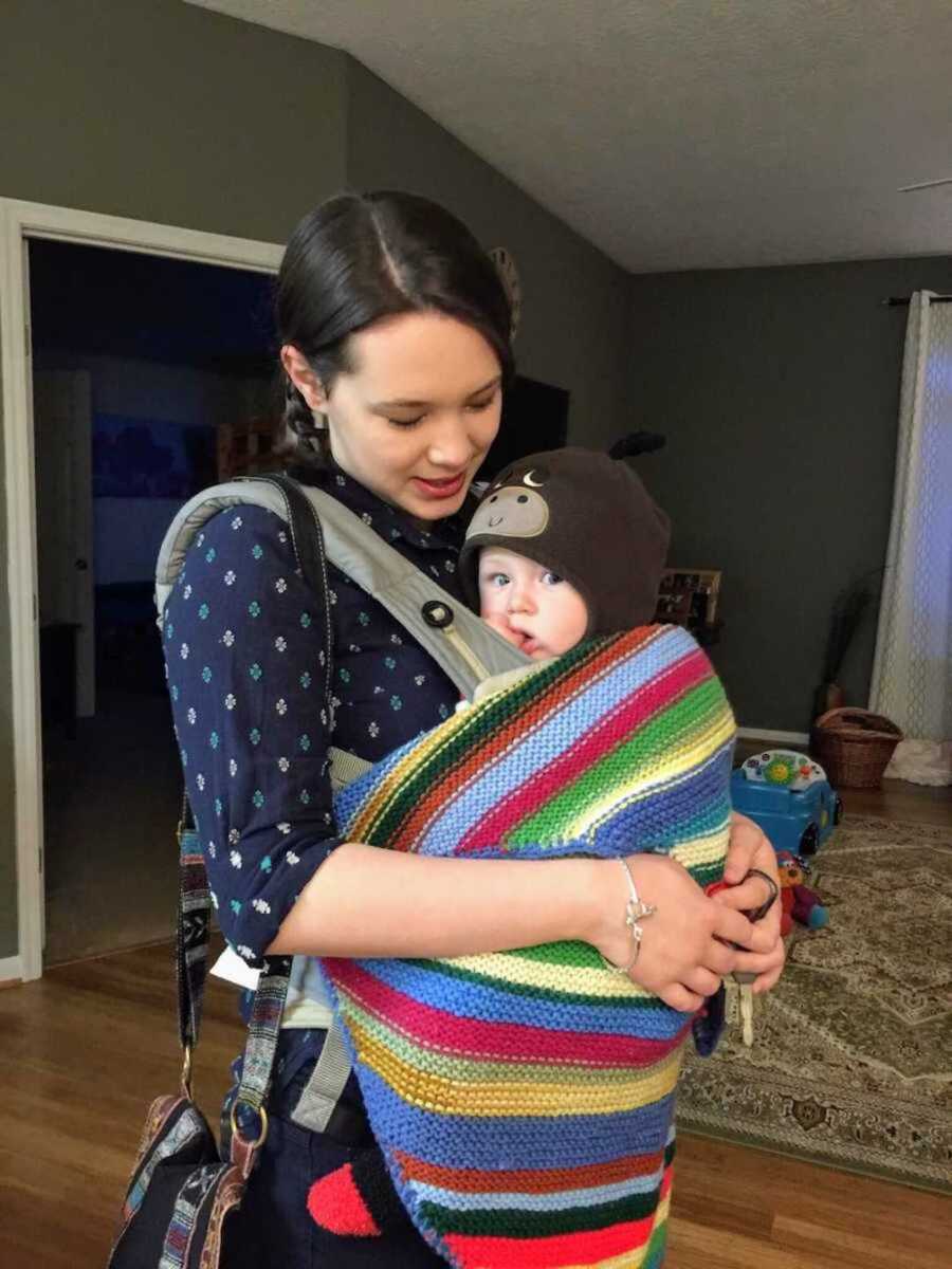 Mom holding infant in rainbow blanket