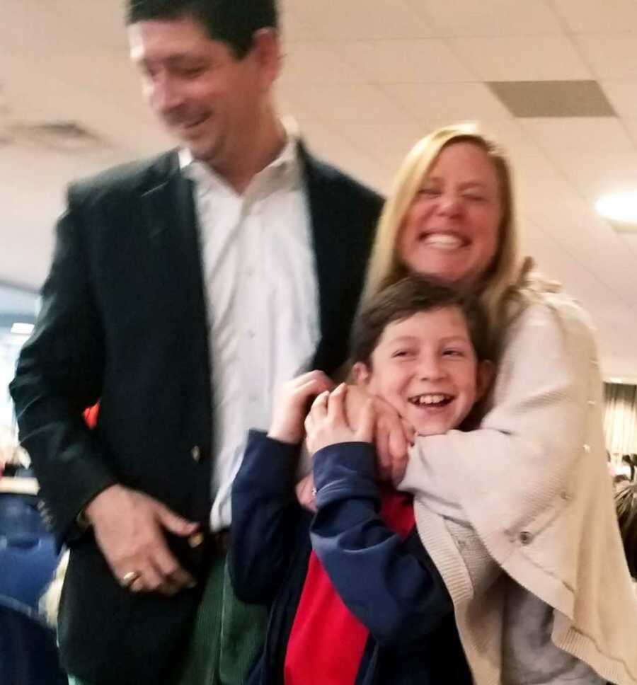 parents smile and hug child