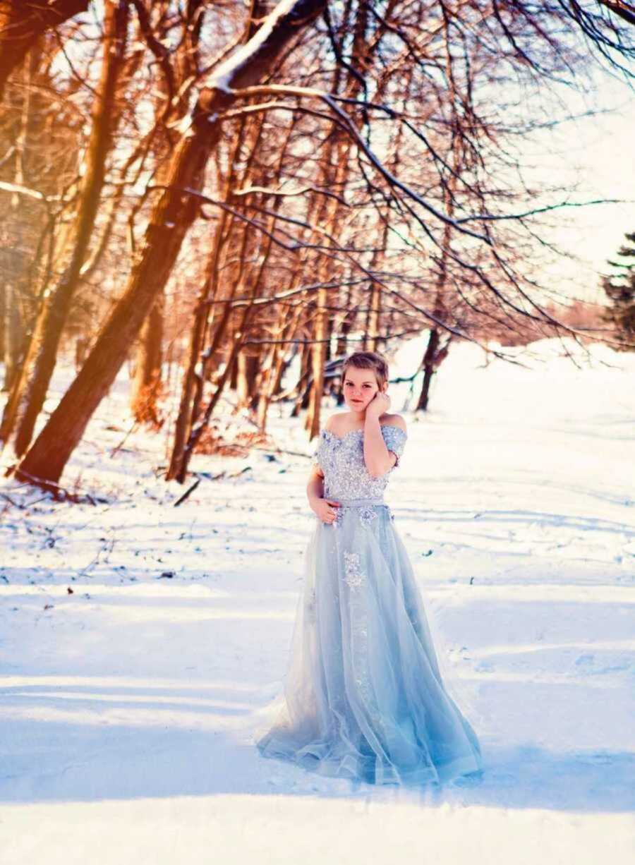Girl in blue gown poses in snow
