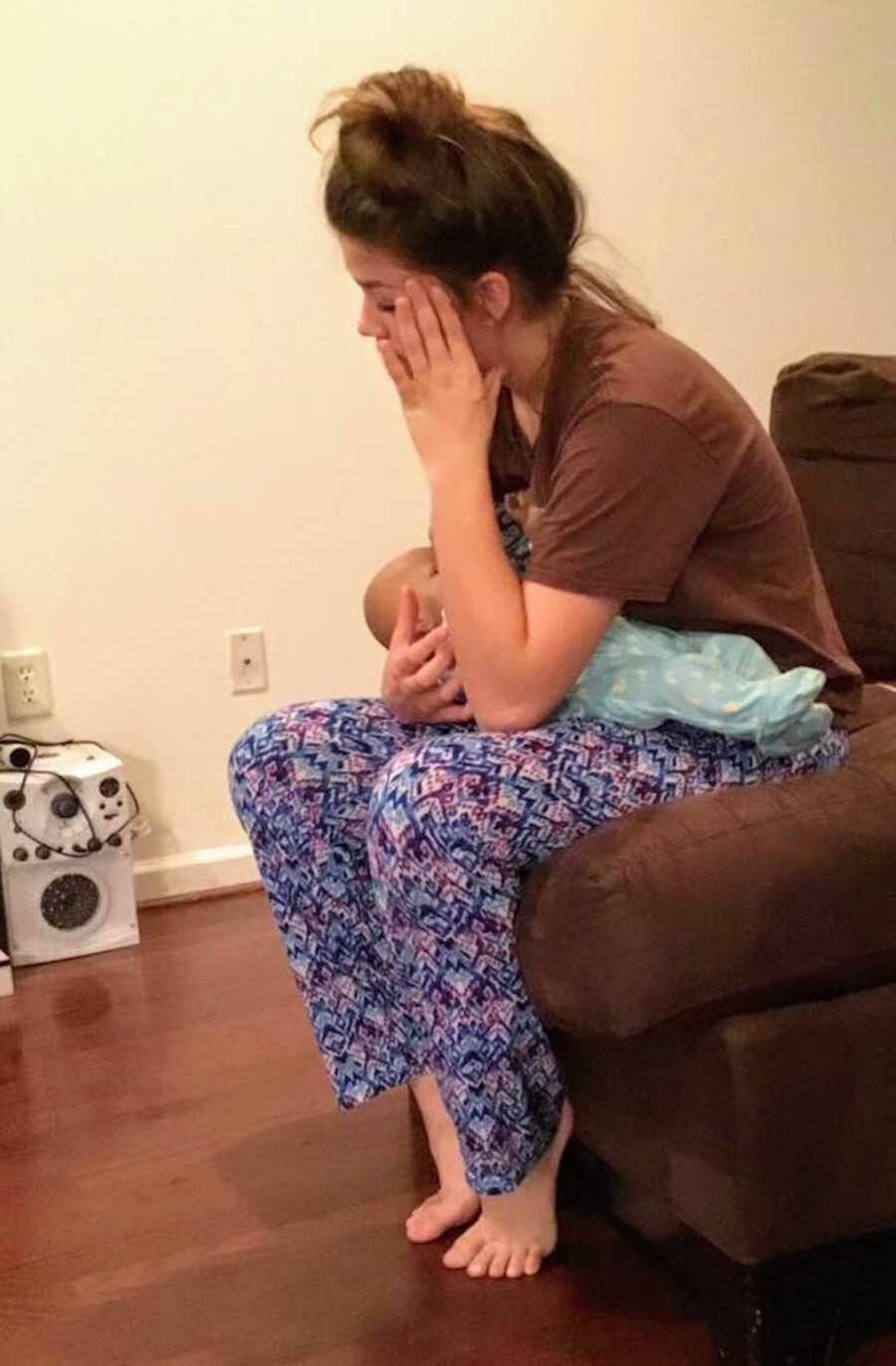 Stressed teen holding fake baby in lap