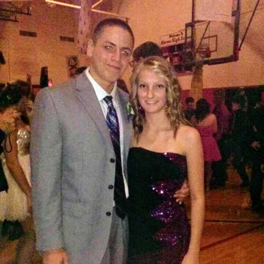 young couple stands at school dance