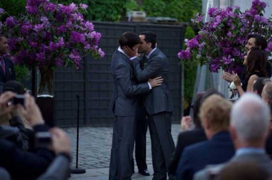 Gay couple at their wedding ceremony kissing