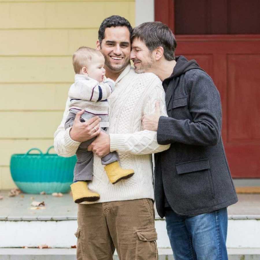 Joyous couple smiling holding their son