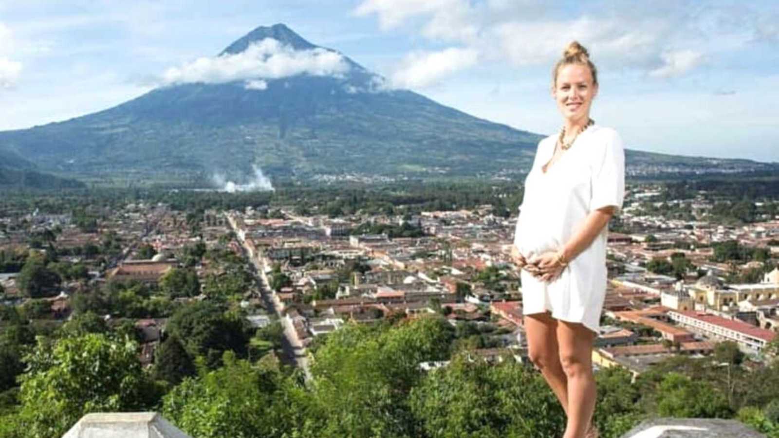 pregnant mom standing in front of mountain