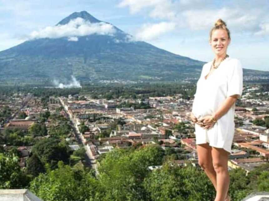 pregnant mom standing in front of mountain