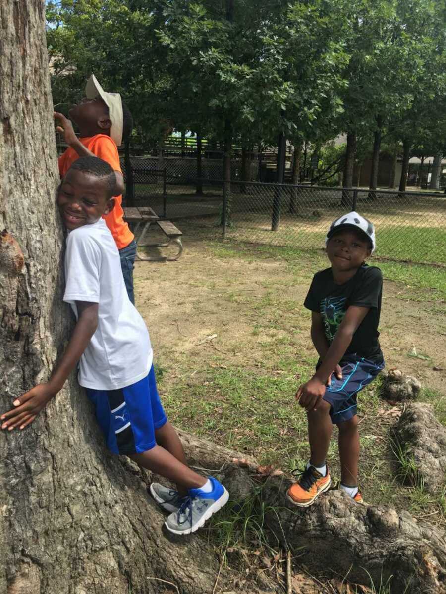 Three brothers playing with tree at park