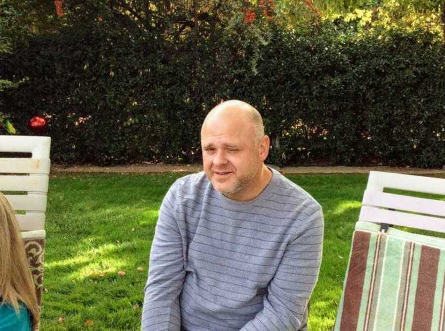 Drug addict in backyard wearing striped gray shirt