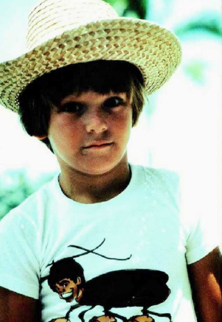 Young boy wearing straw hat and white shirt