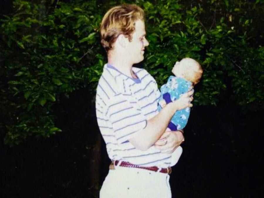 Young dad holding newborn son in hands