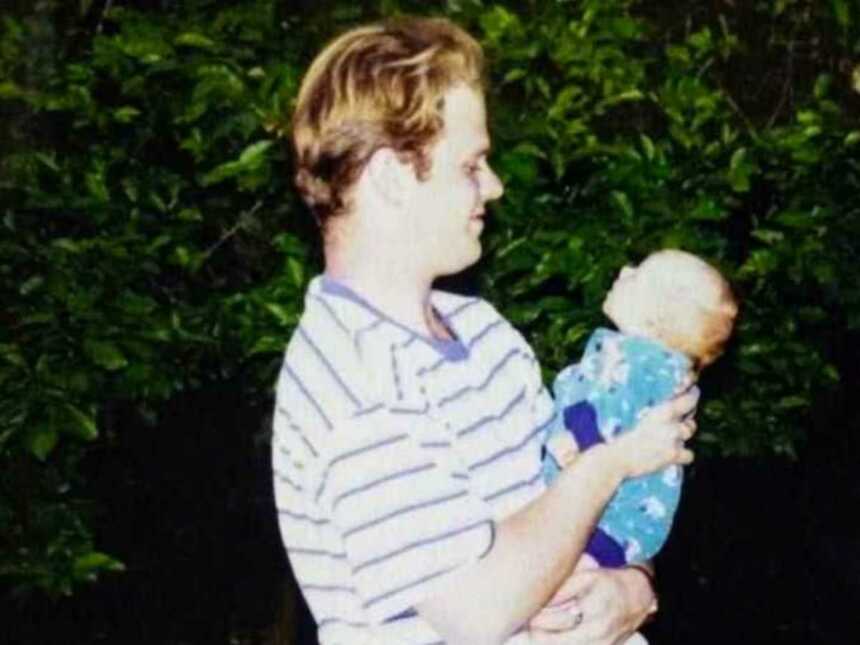Young dad holding newborn in arms