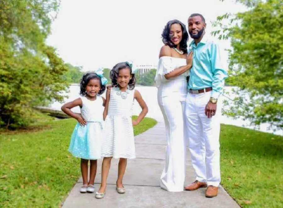 Family of four wearing white attire on sidewalk