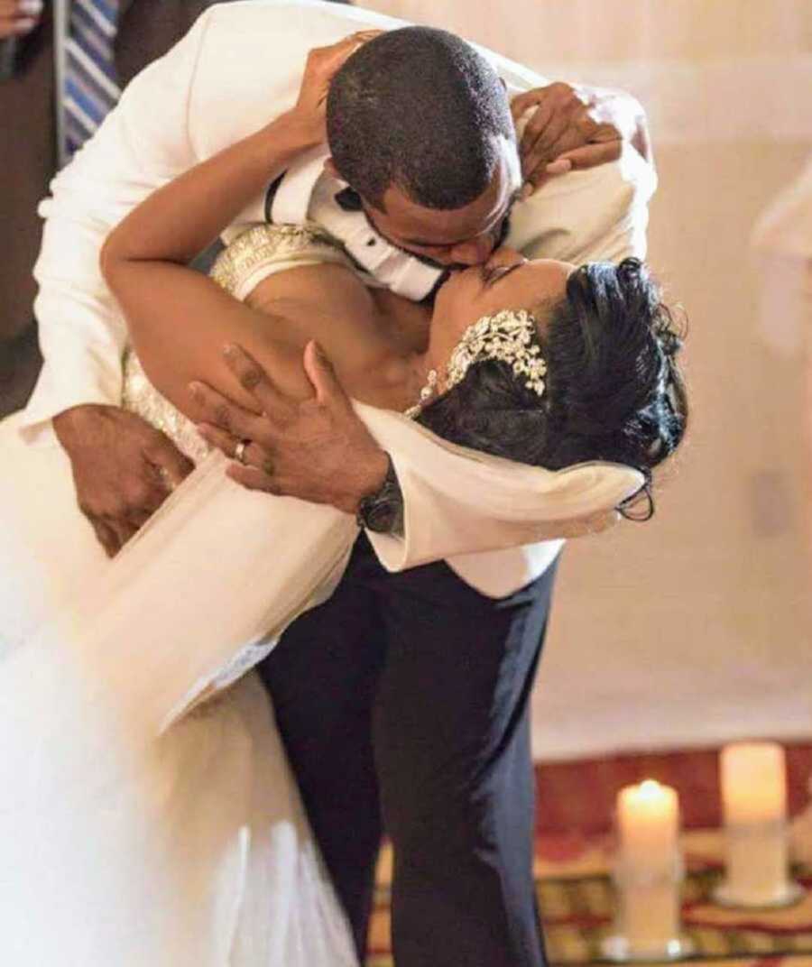 Groom kissing bride in his arms