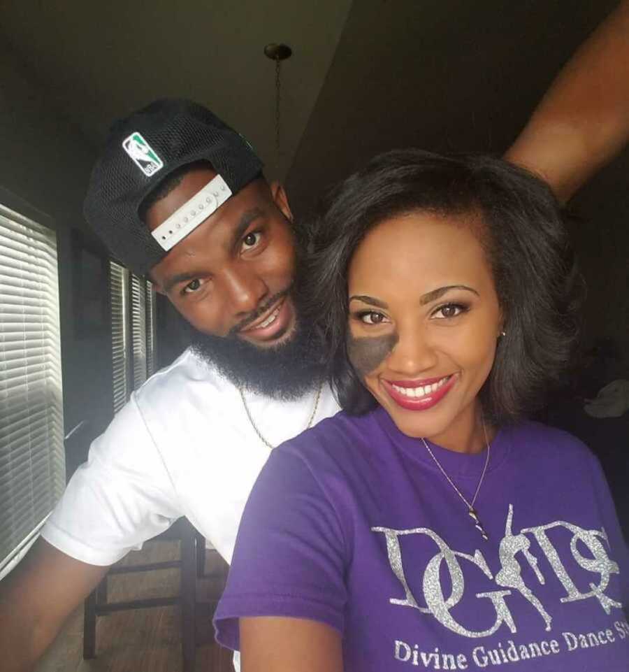 Woman with nevus birthmark in purple shirt smiling next to boyfriend