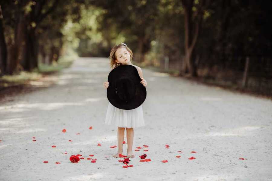 girl holding the hat of newly-deceased dad