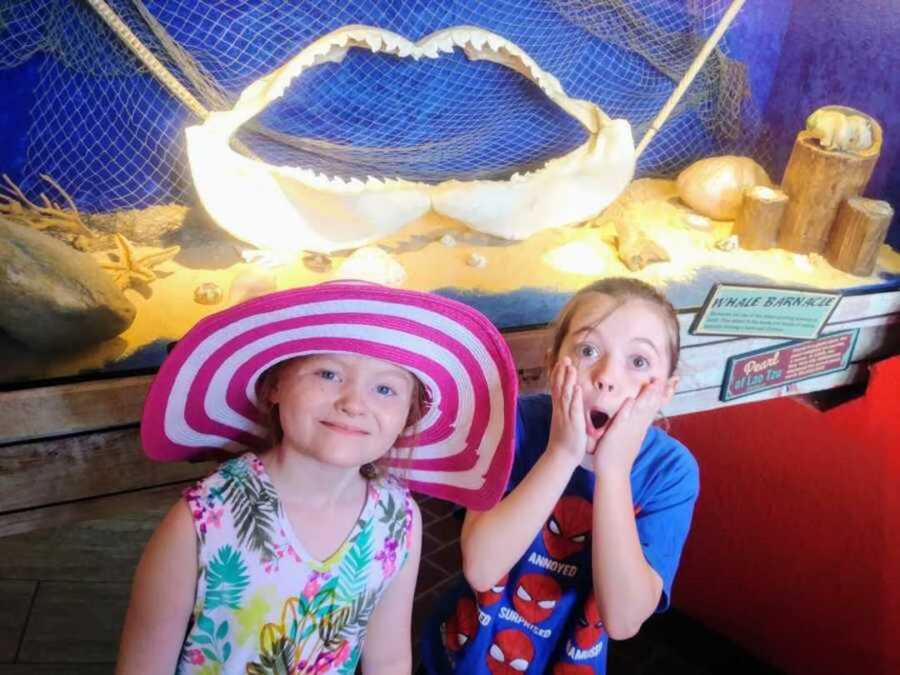 girl with cancer wears floppy hat by sister